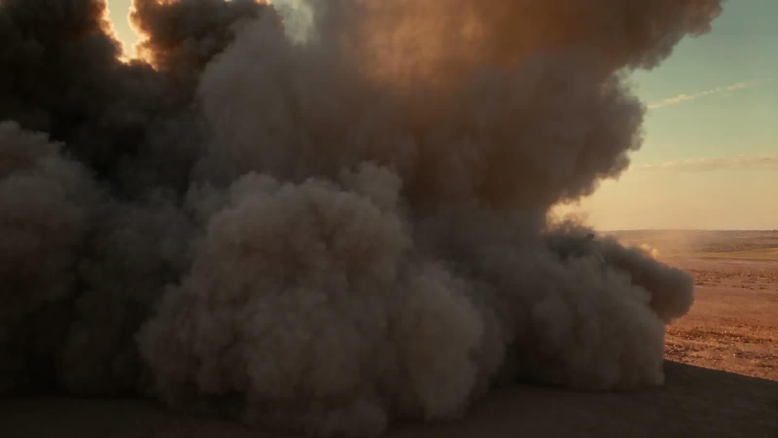 Smoke plume from a rocket launch rolling across a desert range, from the DFGD hero film
